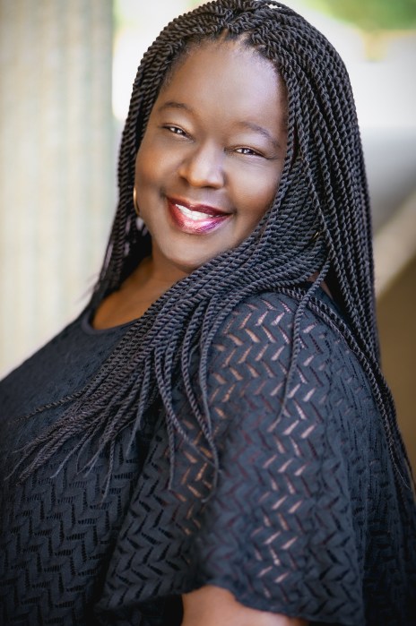 Professional headshot of Tonya Tee, founder of Writing Waves. Tonya is facing sideways and looking directly into the camera with a confident smile, representing the person behind the "Structure and Soul" of the business.